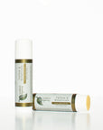Two Tallow & Botanicals anti-aging sticks on a white background